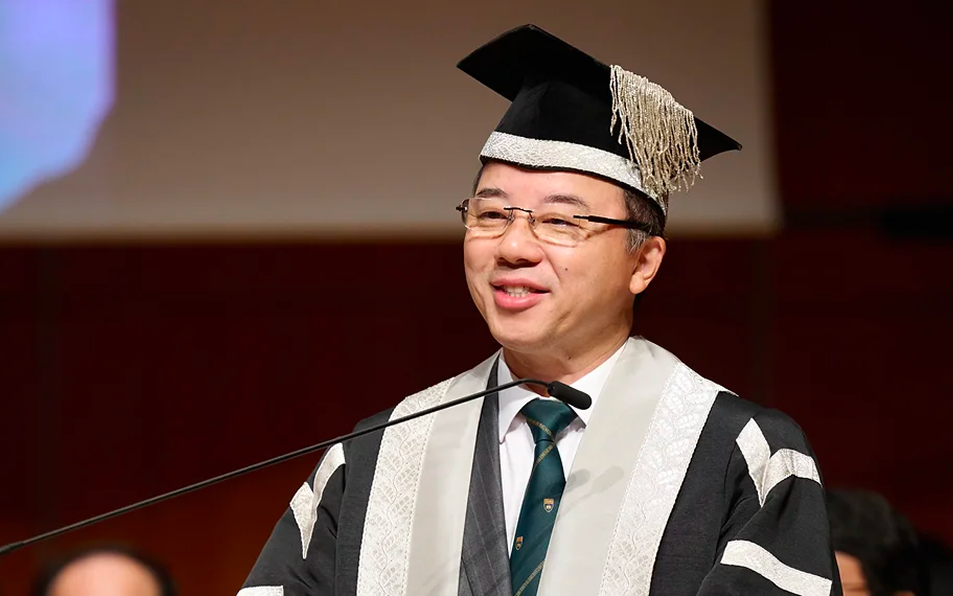 HKU President Xiang Zhang speaking at a microphone while wearing official academic gown and ceremonial cap.