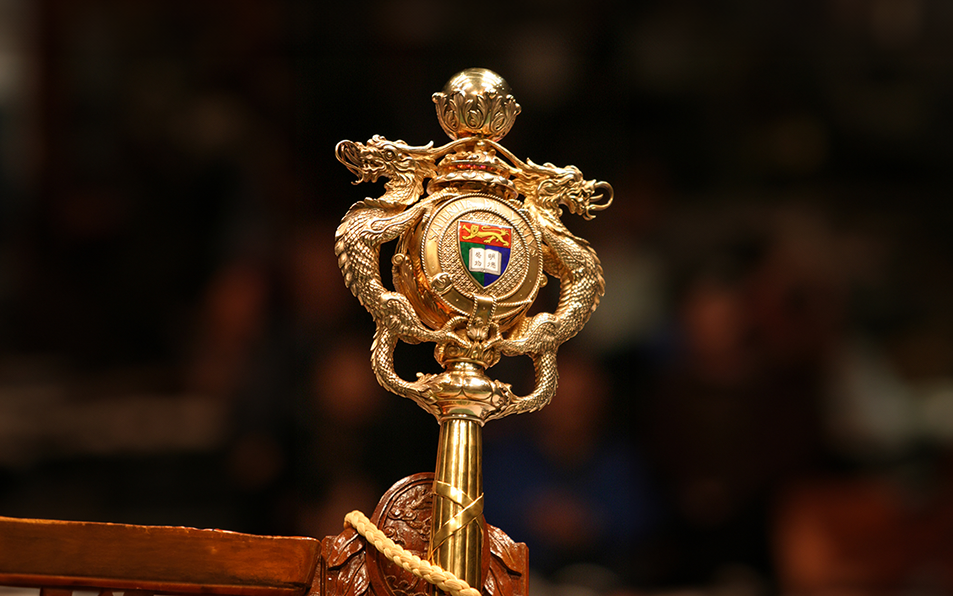 Close-up of HKU ceremonial mace featuring gold dragons framing the university coat of arms.
